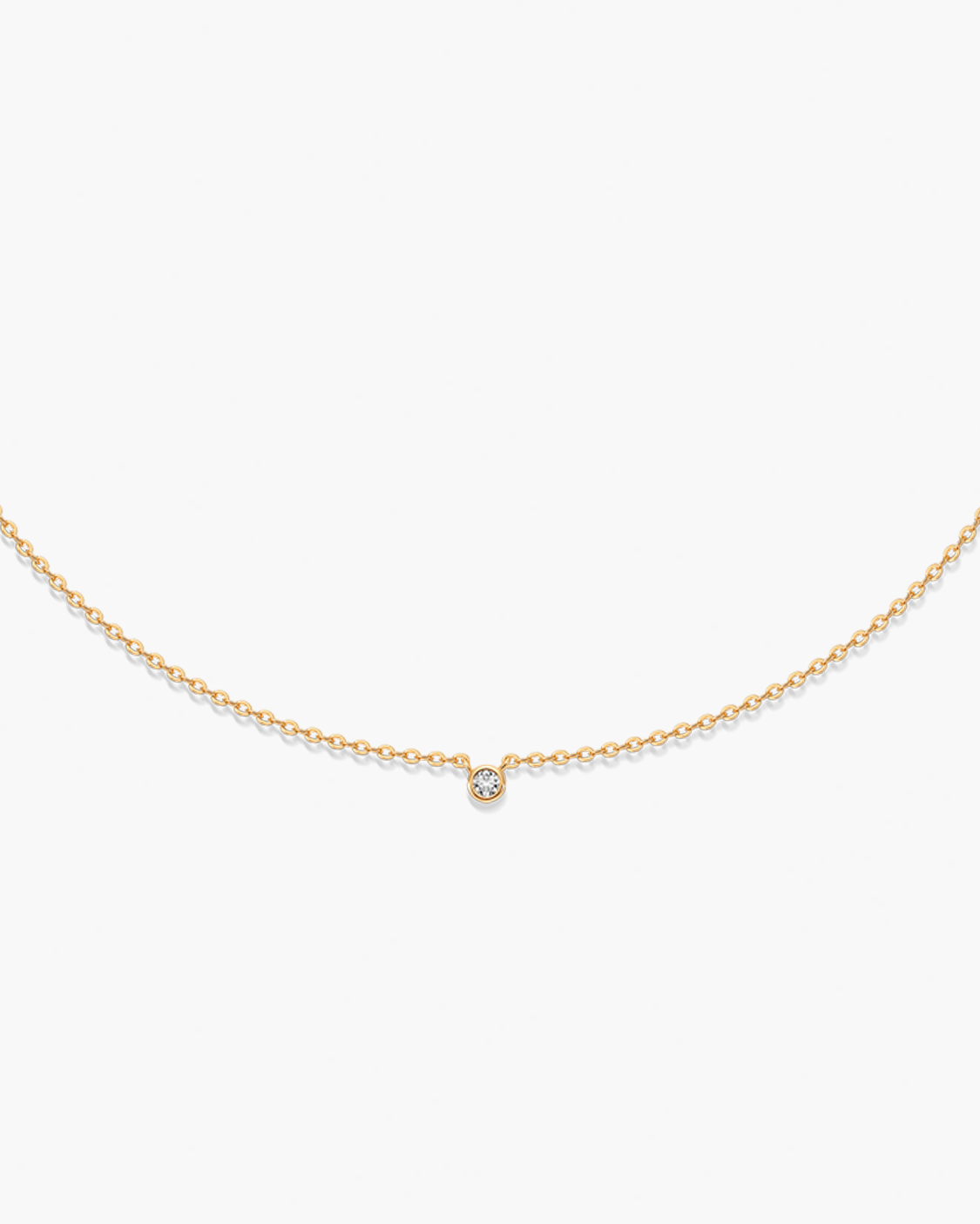 Gold necklace with a small CZ pendant on a white background