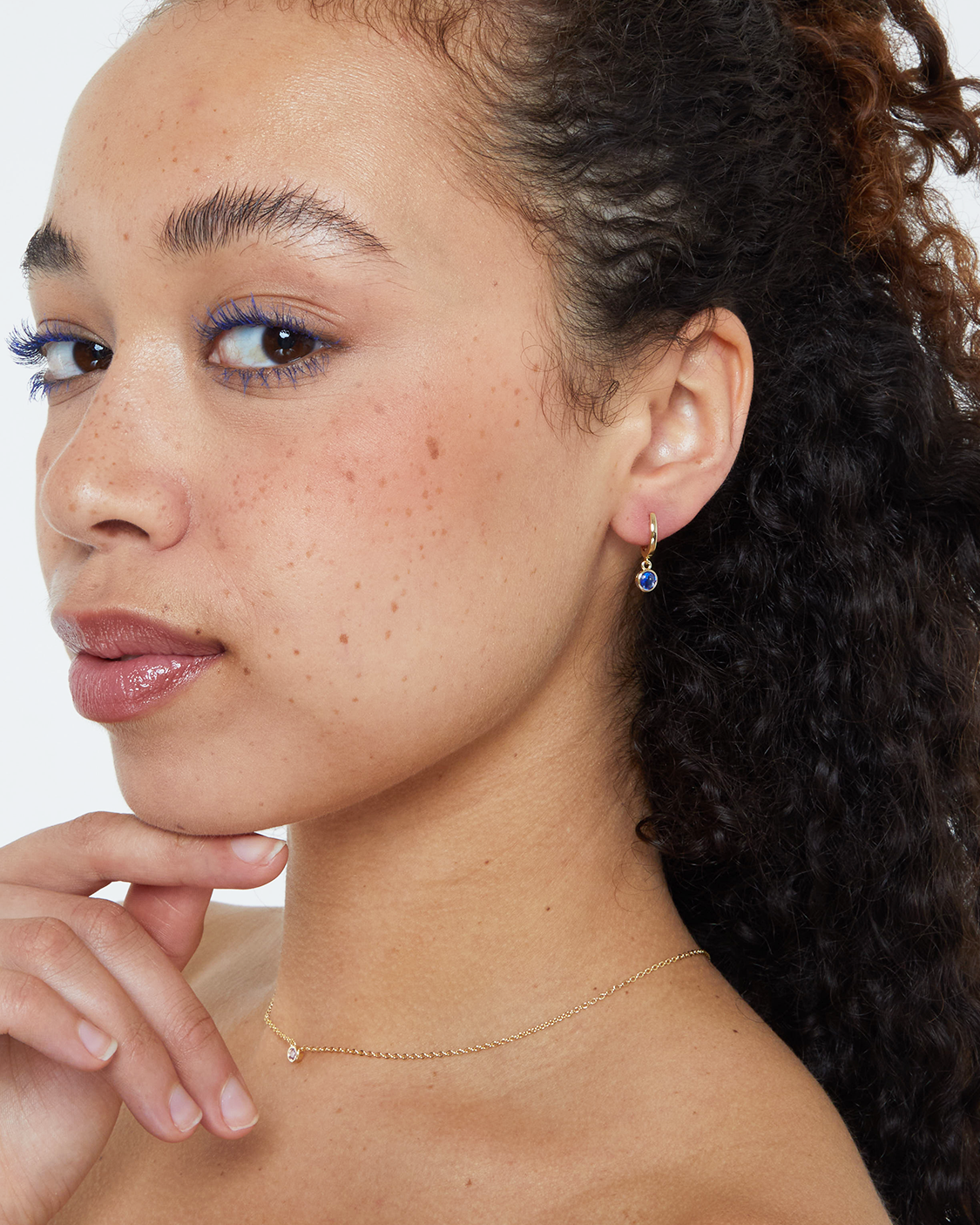 model wearing blue bezel drop earring