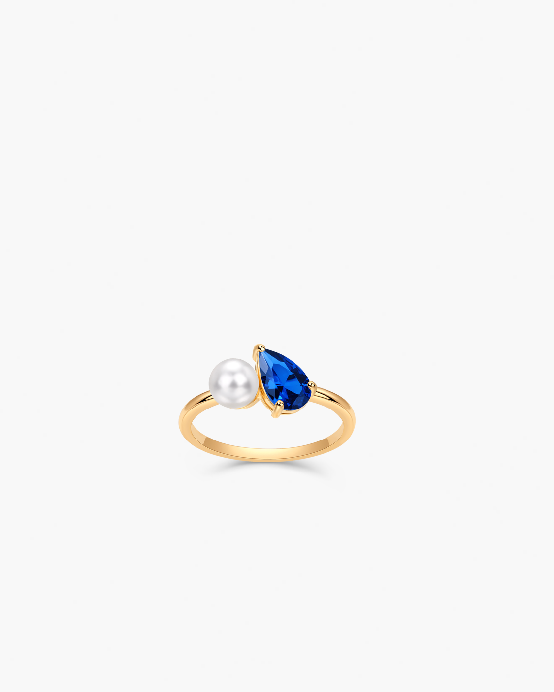 Gold ring with a pearl and blue gemstone.