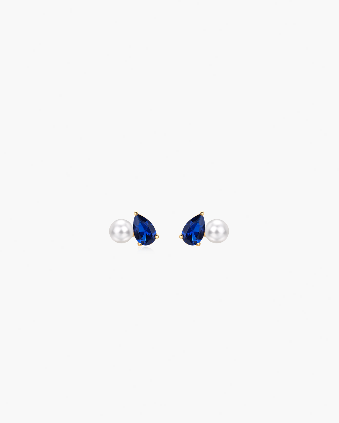 Pair of earrings with teardrop-shaped blue gemstones and pearl-like centers on a white background