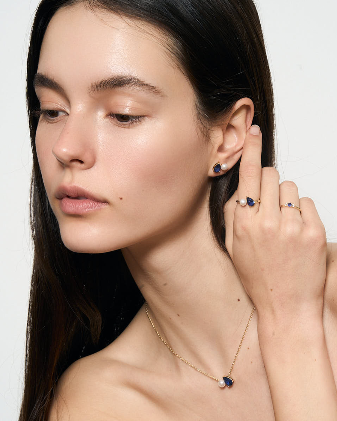 close up of woman wearing blue jewelry set