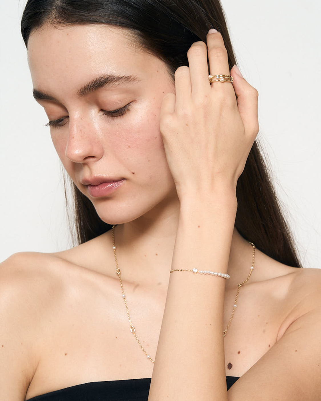 Woman wearing jewelry including a ring, bracelet, and necklace