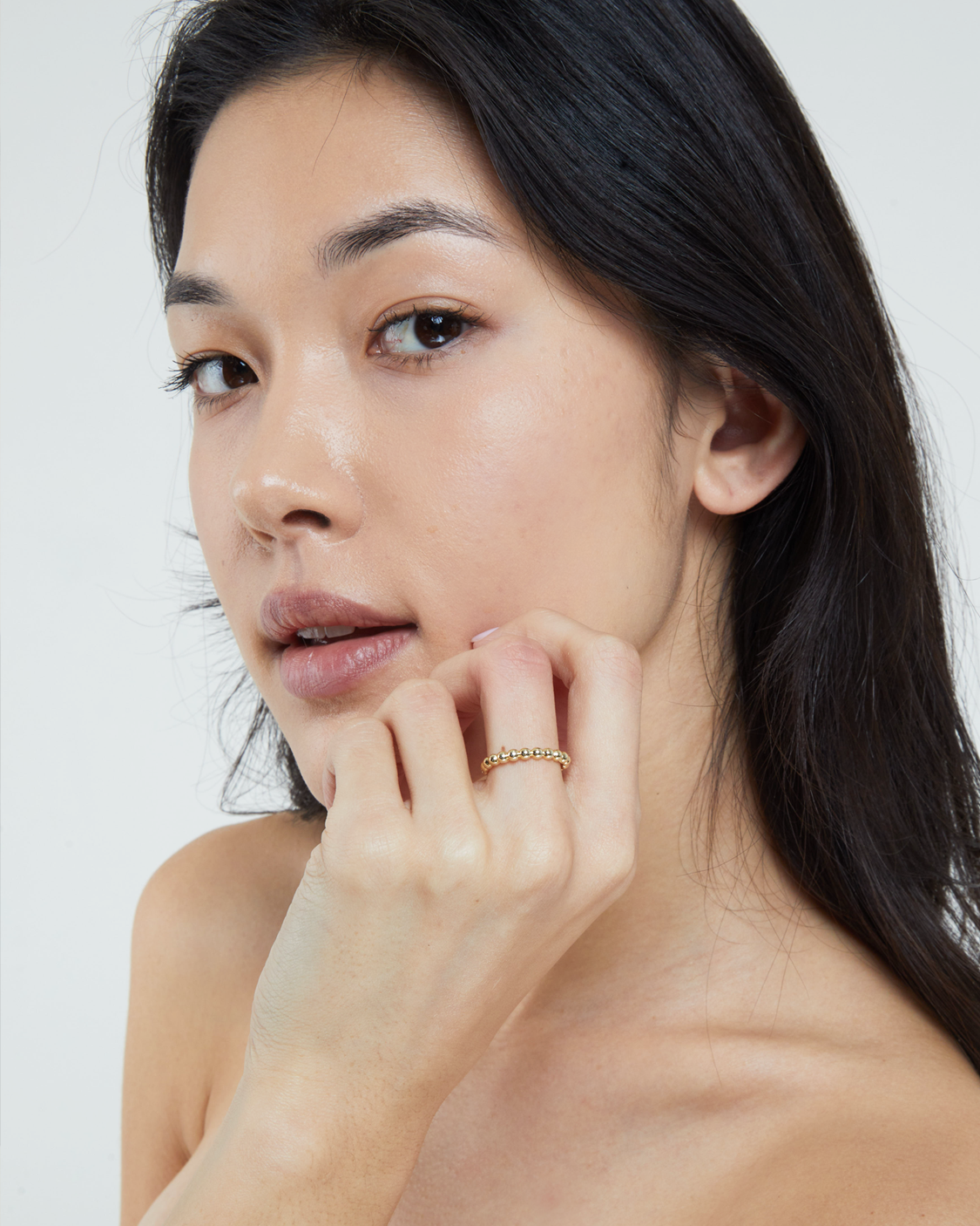 woman wearing gold beads ring