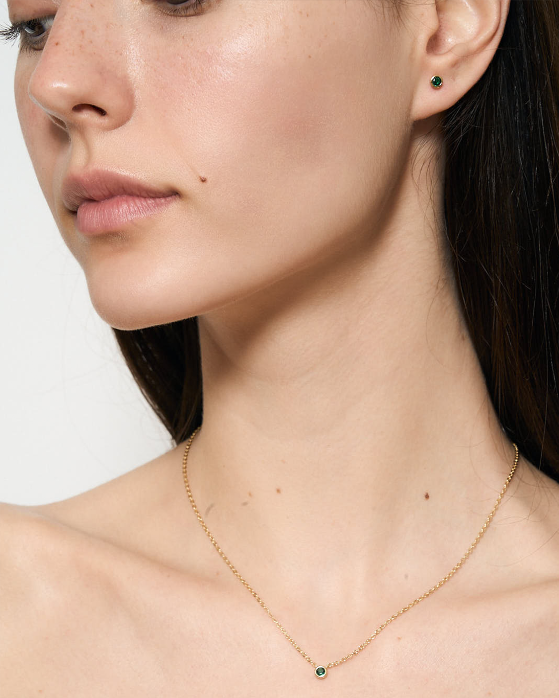 woman wearing green earrings and necklace