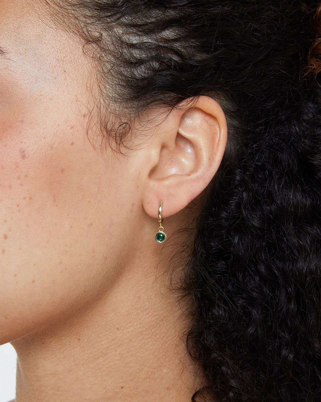 model wearing green bezel drop earring