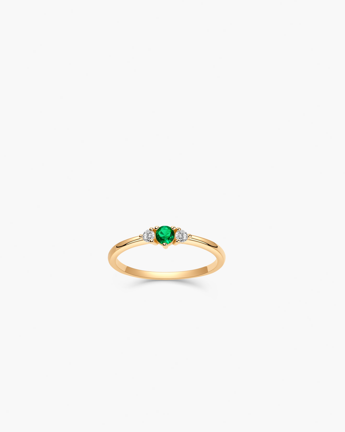 Gold ring with a green gemstone on a white background