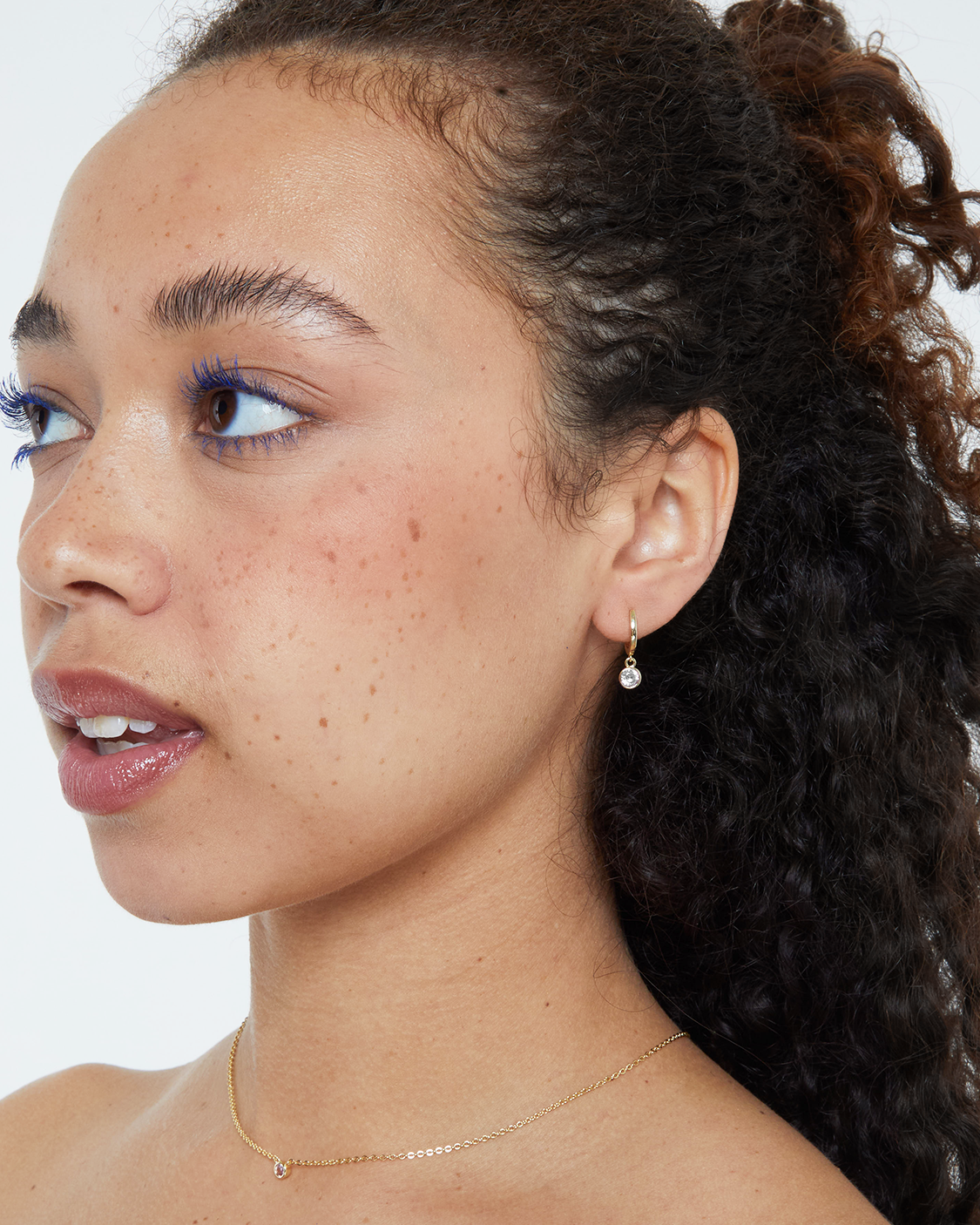 woman wearing white bezel drop earrings